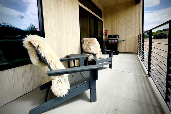 Covered patio with west views.  Two Adirondack chairs, a small table and Weber gas grill