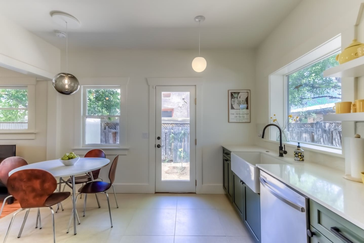 Kitchen with dining area and door to side yard with BBQ