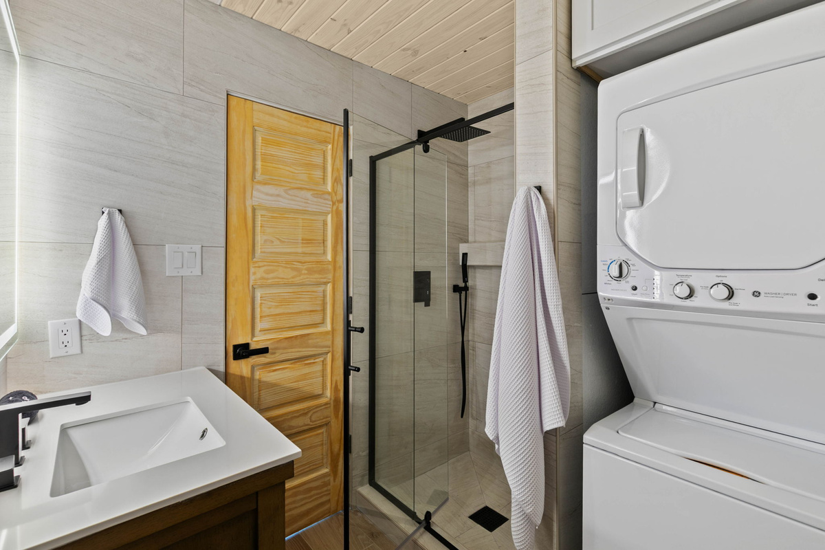 One of four full bathrooms also includes a convenient stacked washer and dryer for guest use.