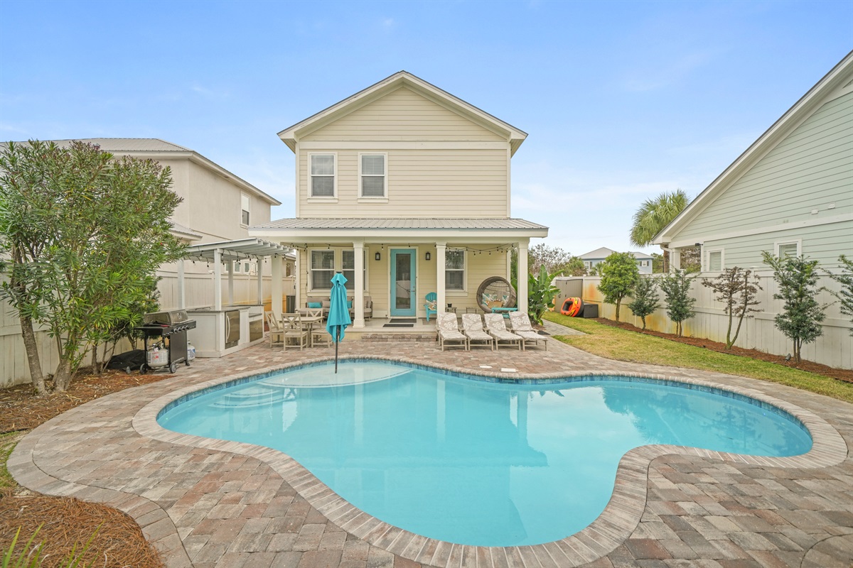 Wide daytime view of the private pool and spacious paver patio.