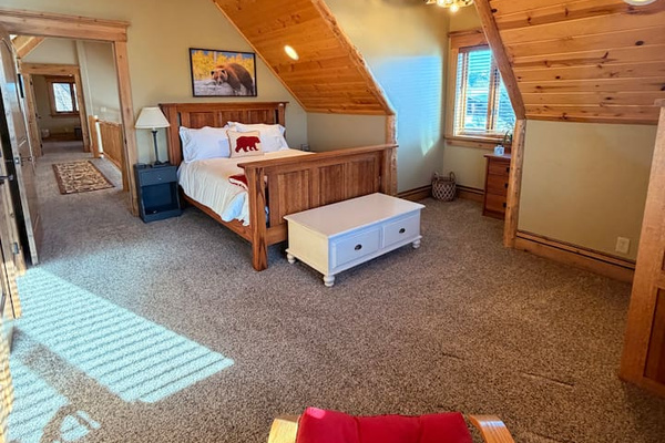 Bedroom 5 is a loft-style retreat, featuring vaulted wood ceilings and beautiful rustic details that create a true lodge experience. Filled with natural light, this upper-level sanctuary offers a queen bed with premium linens -perfect for recharging.