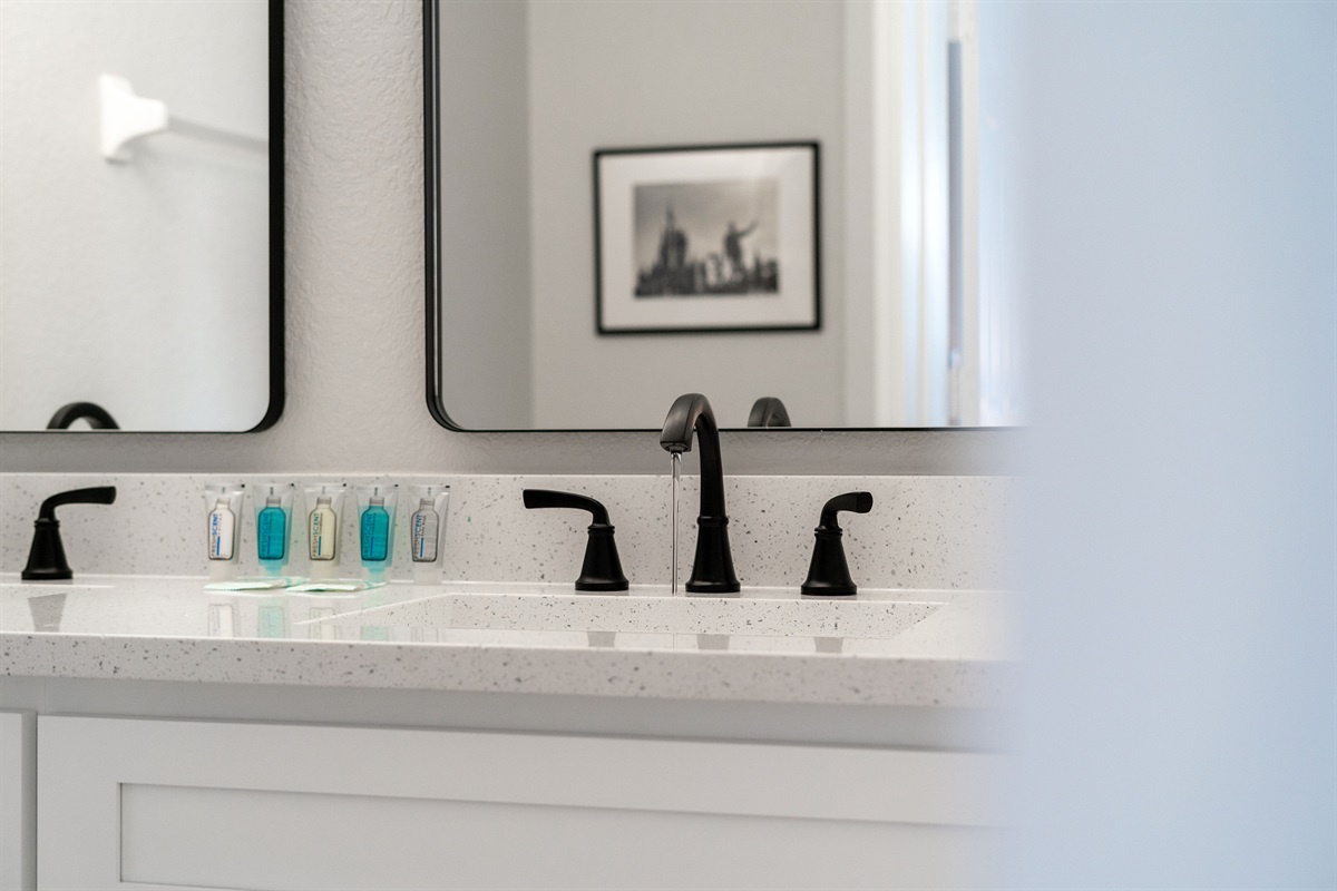 Primary bathroom with a large soaking tub, new cabinets, quartz counters, and double vanity sinks
