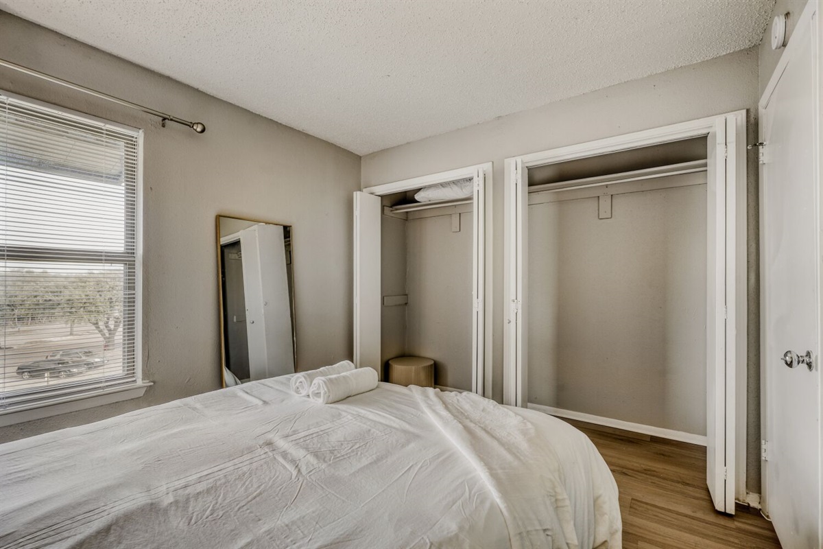 Cozy bedroom with natural light, double closets, and a simple modern design.