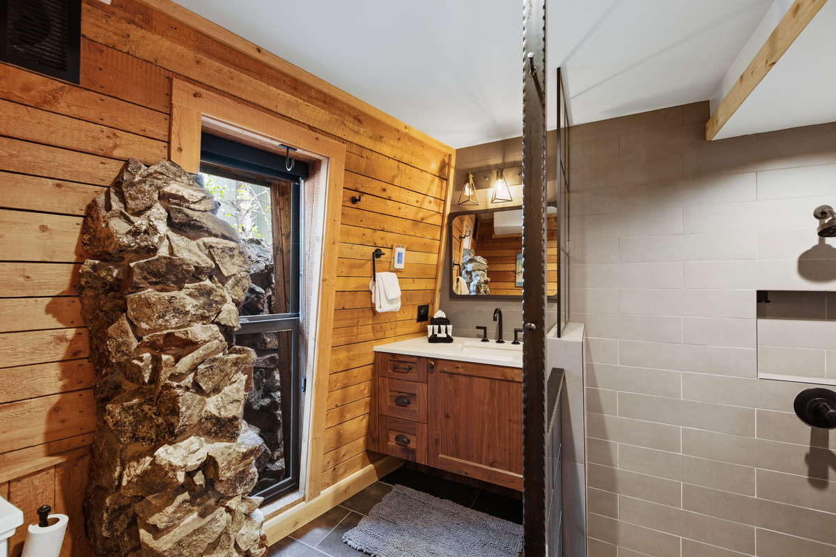 Primary Suite split-section bathroom. This section contains large walk-in shower, single vanity, toilet, and unique design features