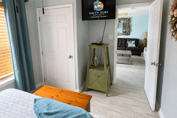 A second bedroom view highlights the TV, storage and easy flow into the living area for a comfortable stay.