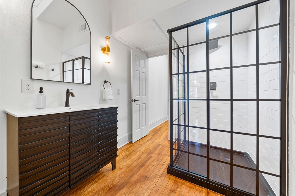 A second look at the bathroom shows its clean design and thoughtful features, including a modern walk-in shower.