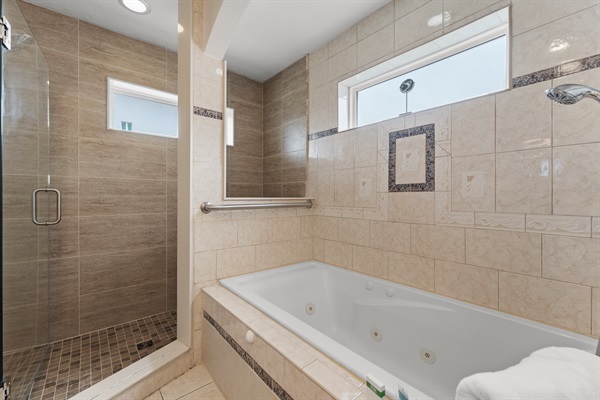 Gorgeous, roomy master ensuite bathroom with a walk-in shower featuring dual showerheads and a large soaking bathtub, perfect for relaxing at day's end.