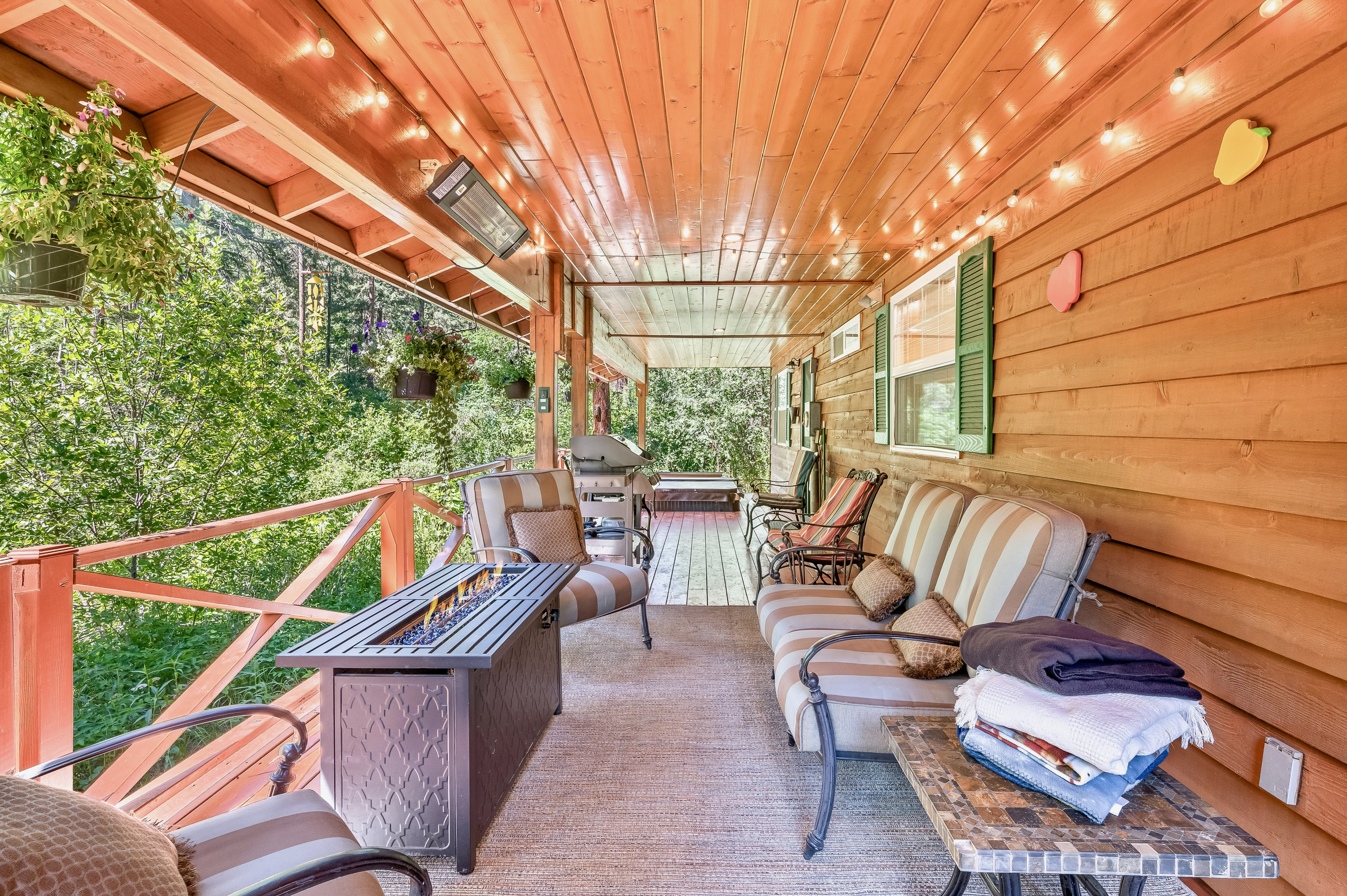 Large covered back porch includes seating, fire table, outdoor heater, BBQ and hot tub