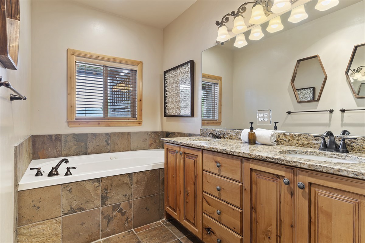 Spa-like bathroom featuring a soaking tub and dual sinks.