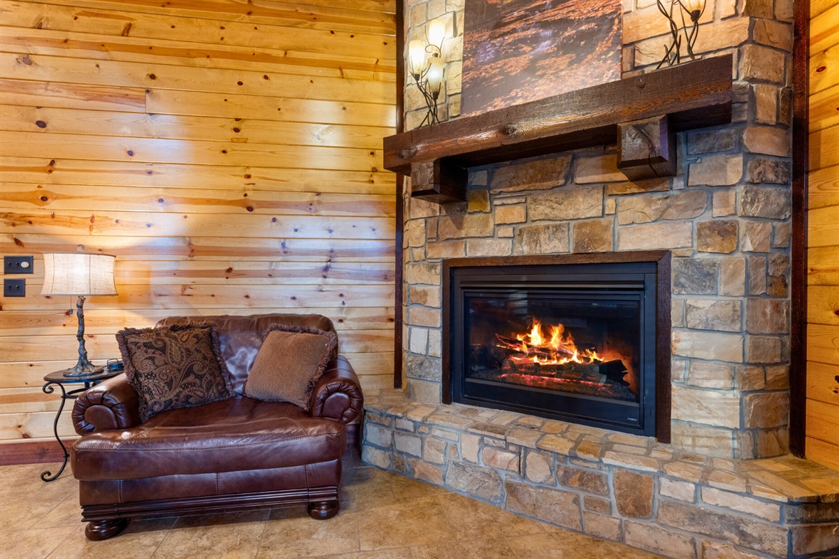 Stone hearth and comfy reading chair for relaxing fireside moments.