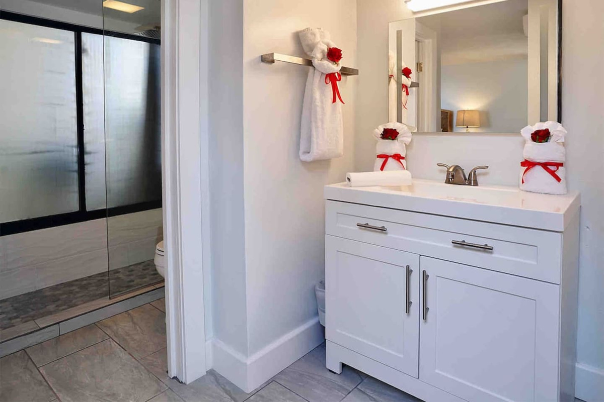 Clean linens and large mirror in the separate sink area