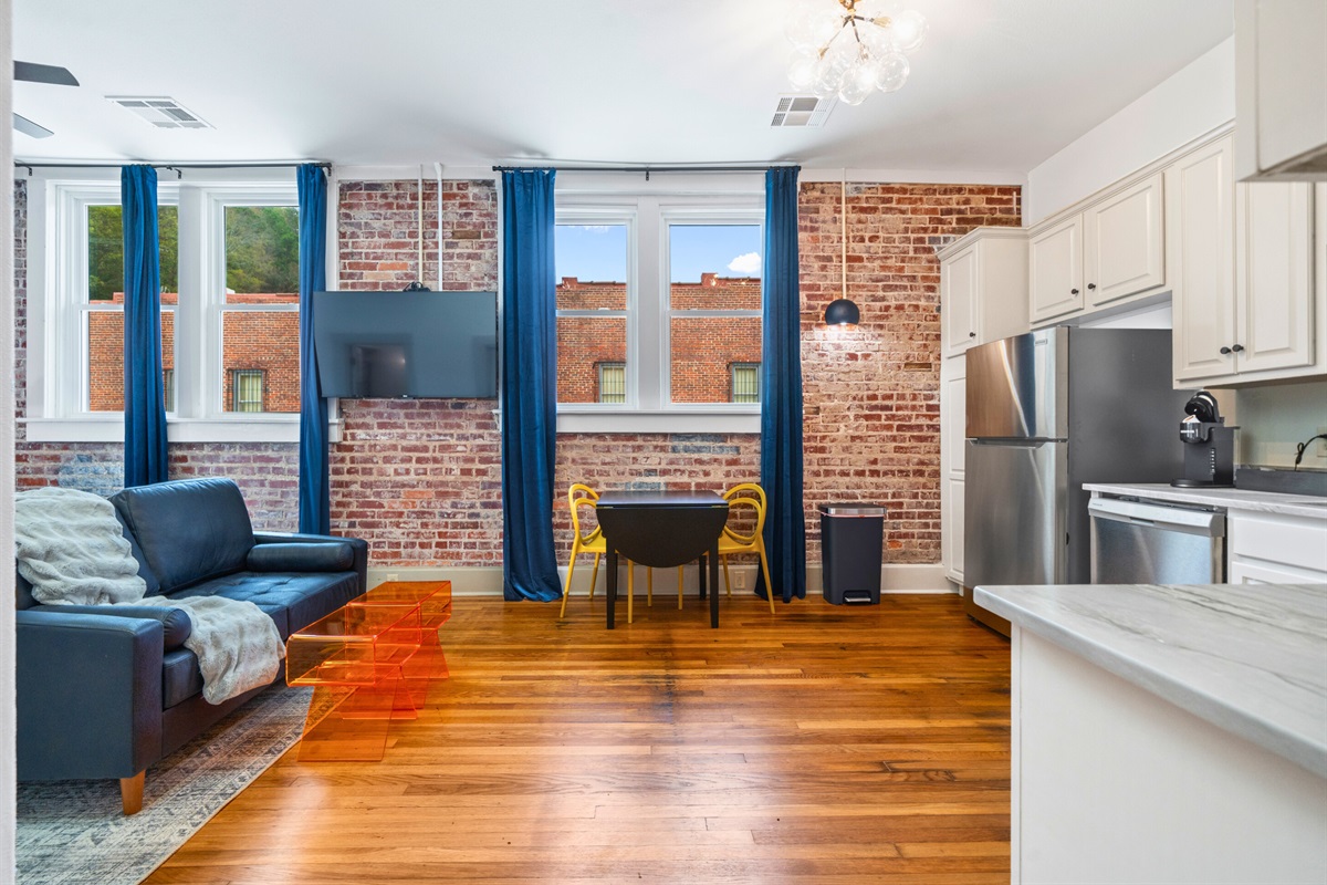 A stylish living and dining space combines cozy furnishings with bold decor, making it the perfect spot to unwind and connect.
