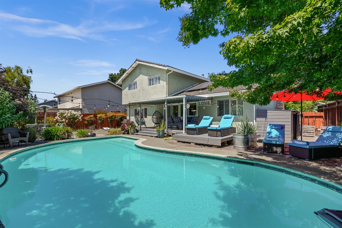 Private backyard retreat with a sparkling pool, outdoor seating, and space to relax and enjoy Napa Valley’s beautiful weather.