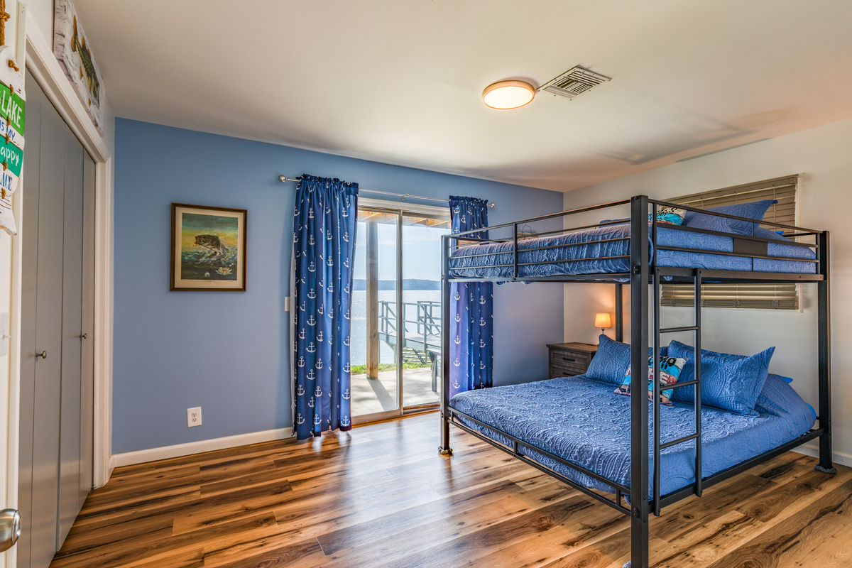 The downstairs bunkroom features a queen-over-queen bunk and direct access to the lake-facing deck.