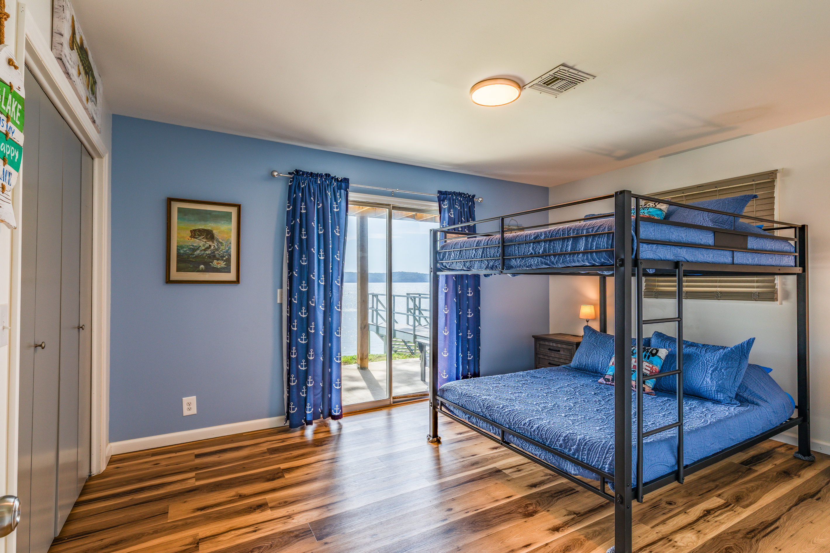 The downstairs bunkroom features a queen-over-queen bunk and direct access to the lake-facing deck.