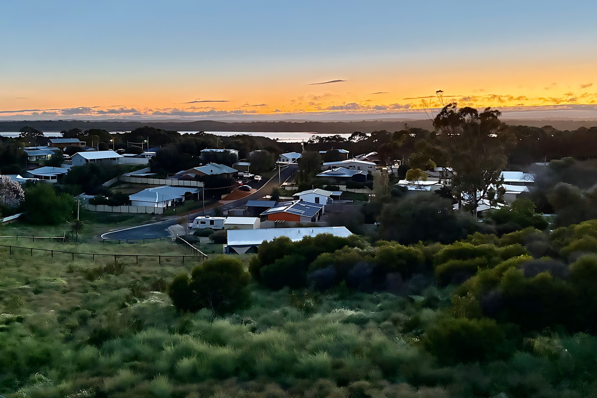 Dusk over Preston Beach from Lake Views & Coastal Escape, with native bushland in the foreground and Lake Preston catching the last light below the tree line of Yalgorup National Park.