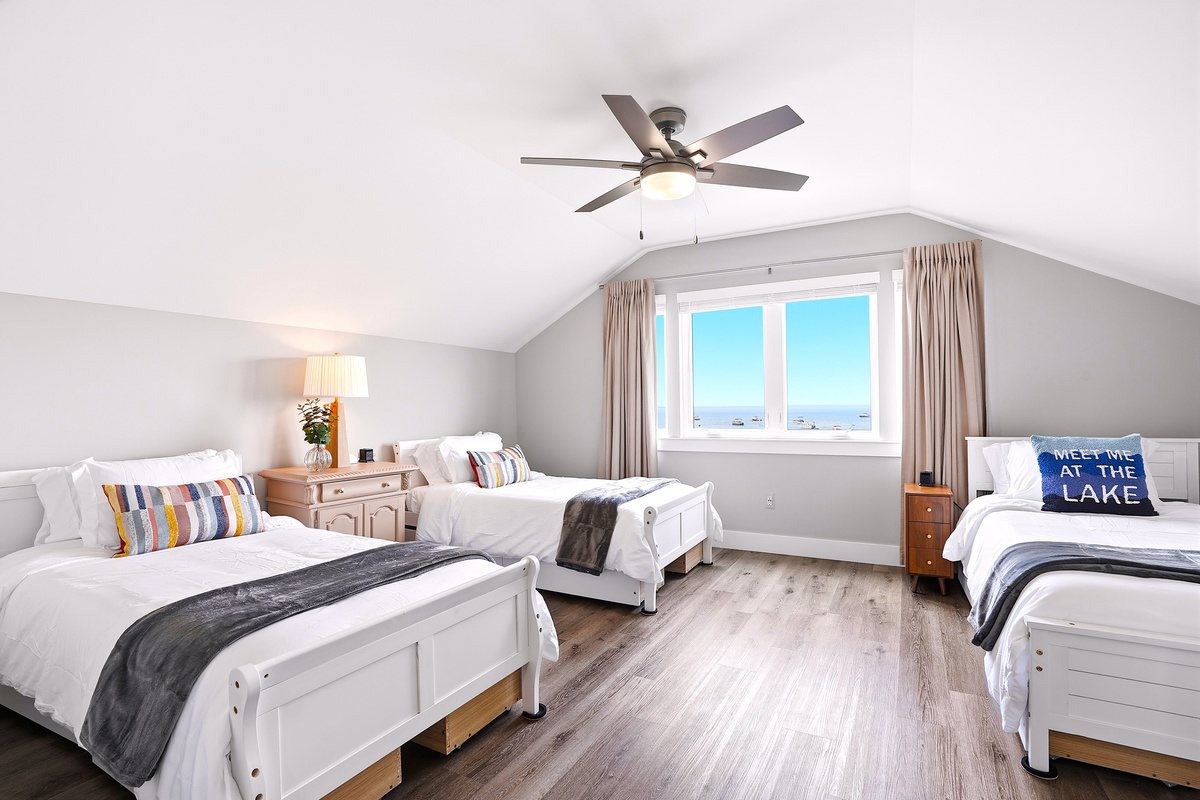 Welcome to the third-floor retreat—a spacious bedroom designed with families and groups in mind. Featuring multiple beds, a private layout, and beautiful Lake St. Clair views, it's the perfect space for everyone to settle in comfortably.