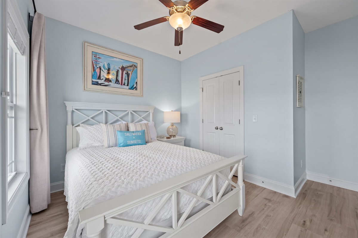 4th bedroom on the top floor just off of the main living space, queen bed with crisp white linens and plenty of natural light 