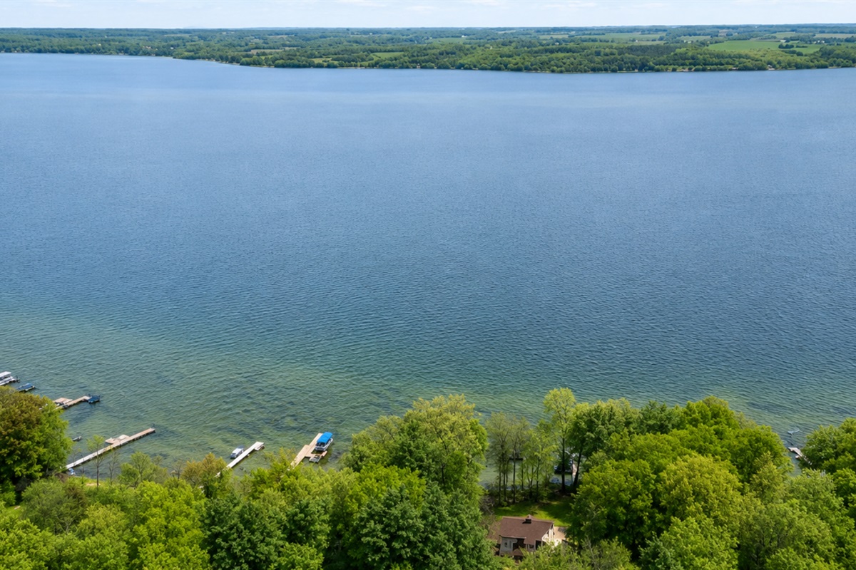 Soaring aerial reveals endless Cayuga Lake vistas and our secluded lakefront hideaway nestled in lush Finger Lakes trees—privacy with a panorama 🌊🌲✨