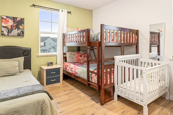 Kid-friendly room with bunk bed, twin bed, and crib—perfect for families