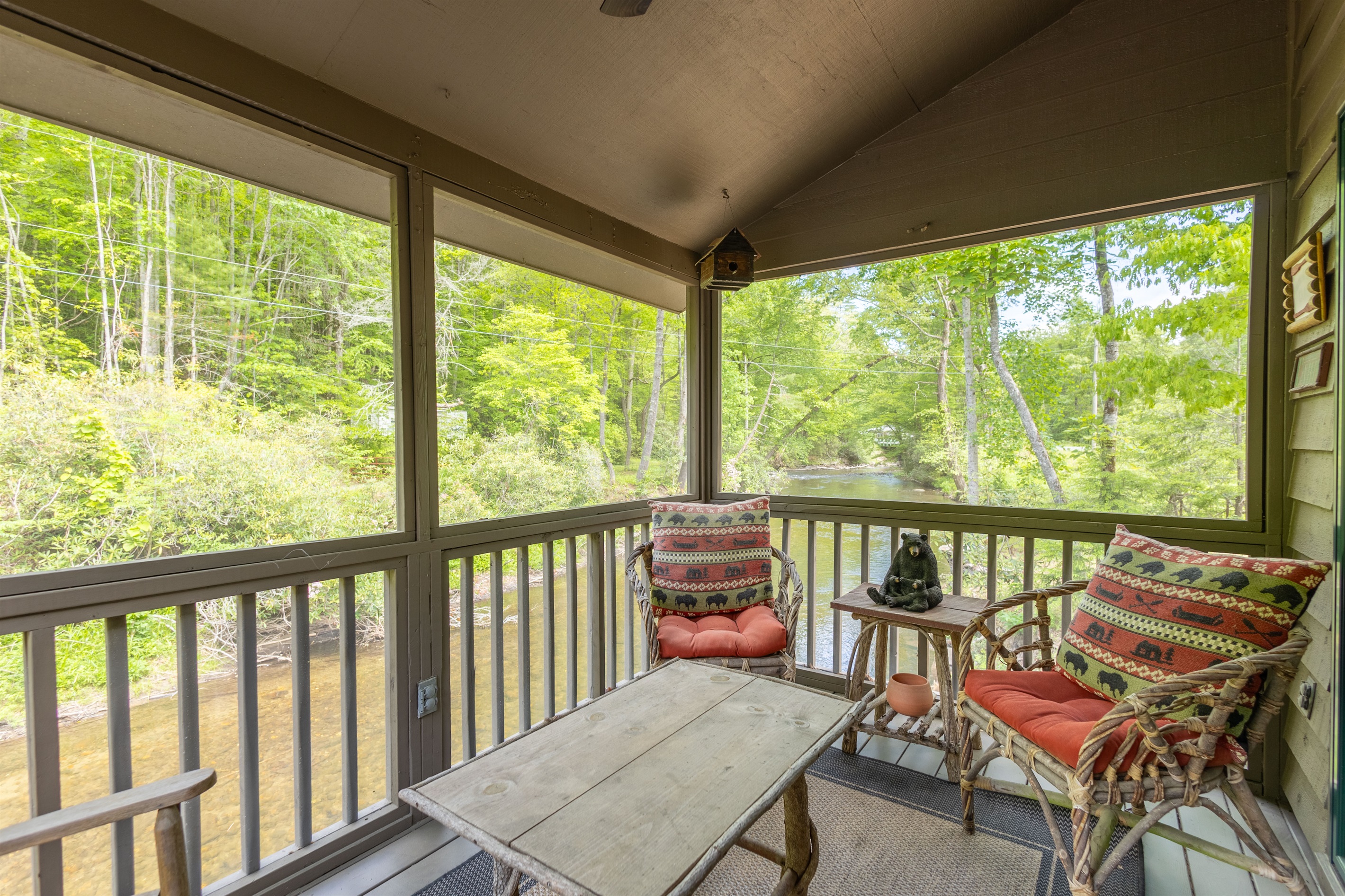 The screened-in porch offers a peaceful place to relax while enjoying the sights and sounds of Snowbird Creek without worrying about the elements.