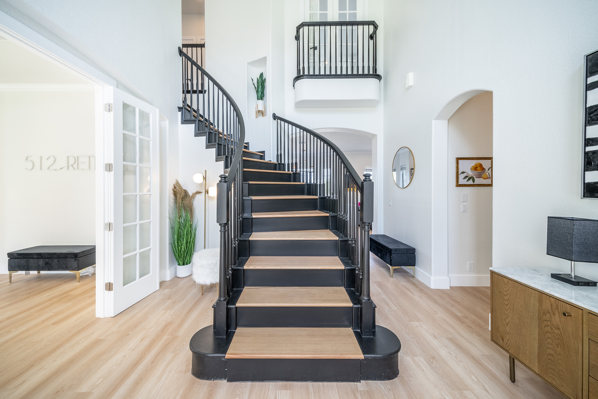 A statement spiral staircase anchors this bright, open-concept living space.