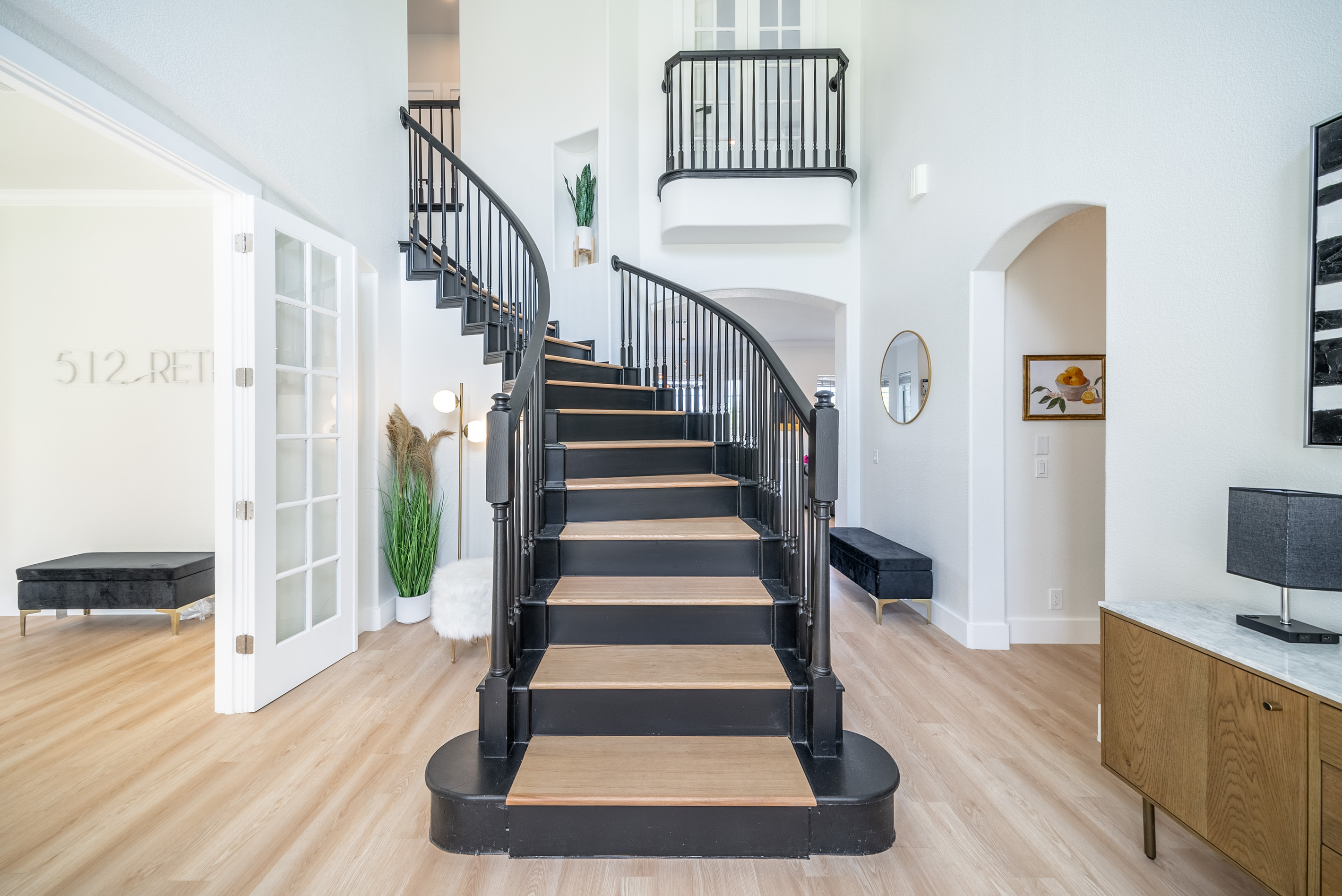 A statement spiral staircase anchors this bright, open-concept living space.