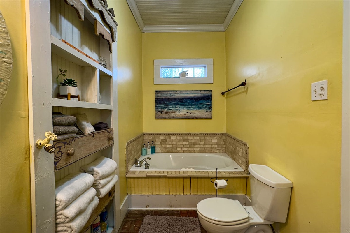 Cheerful bathroom with a soaking tub, fresh towels, and bright coastal colors for a refreshing start or end to your day.