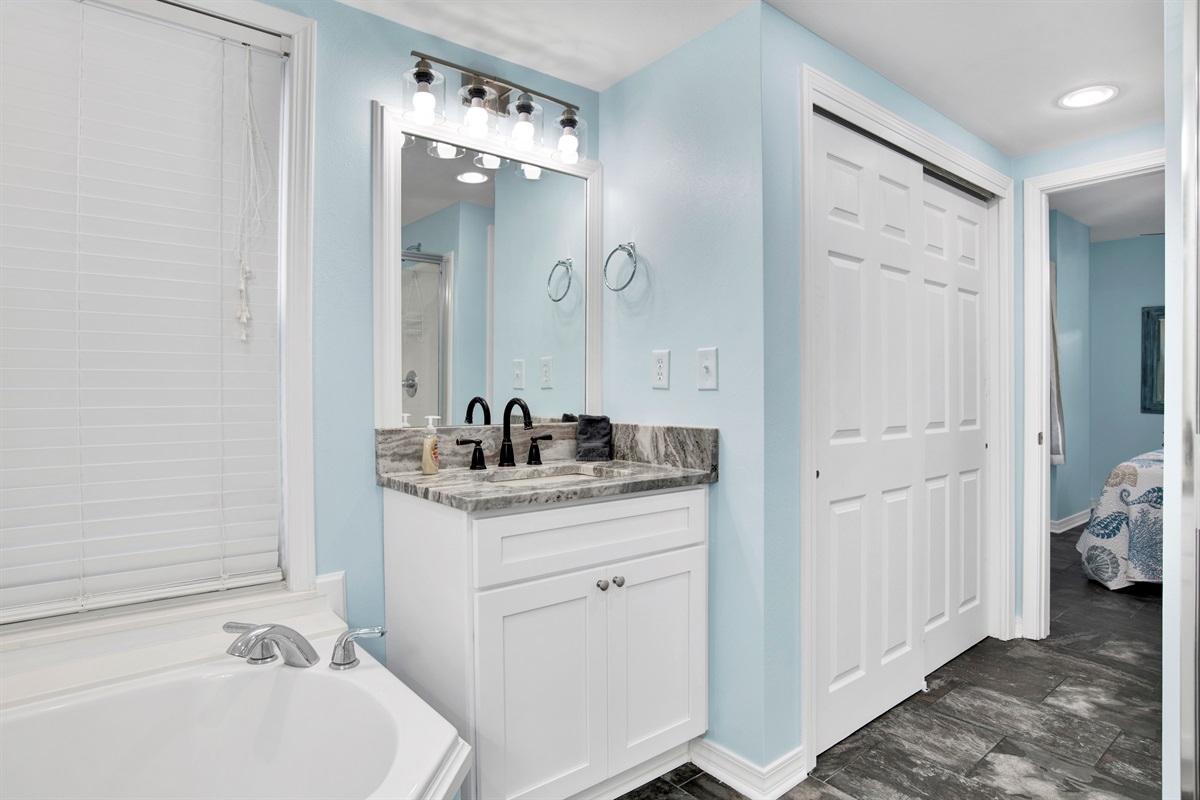 Primary Bathroom with 2 vanities, soaker tub, stand up shower and water closet toilet area