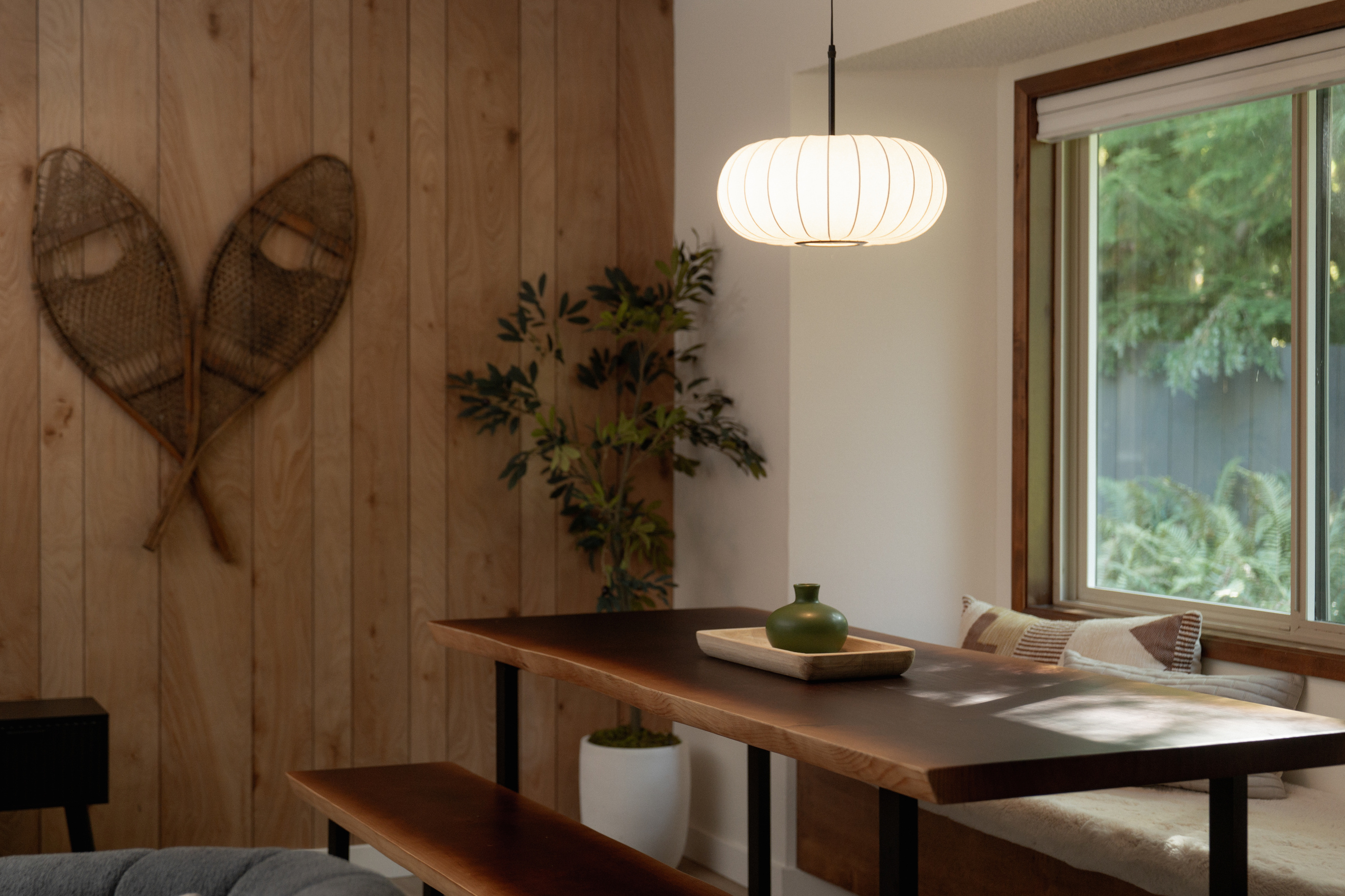 A cozy dining nook under vintage snowshoes — pull up the bench and dig in.