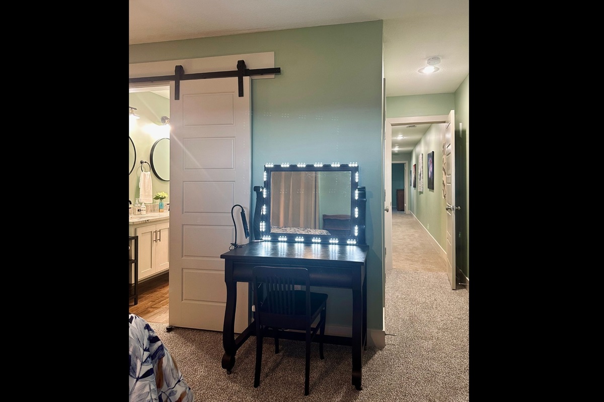 Primary suite desk illuminated with vanity lighting, ideal for morning routines or focused remote work.