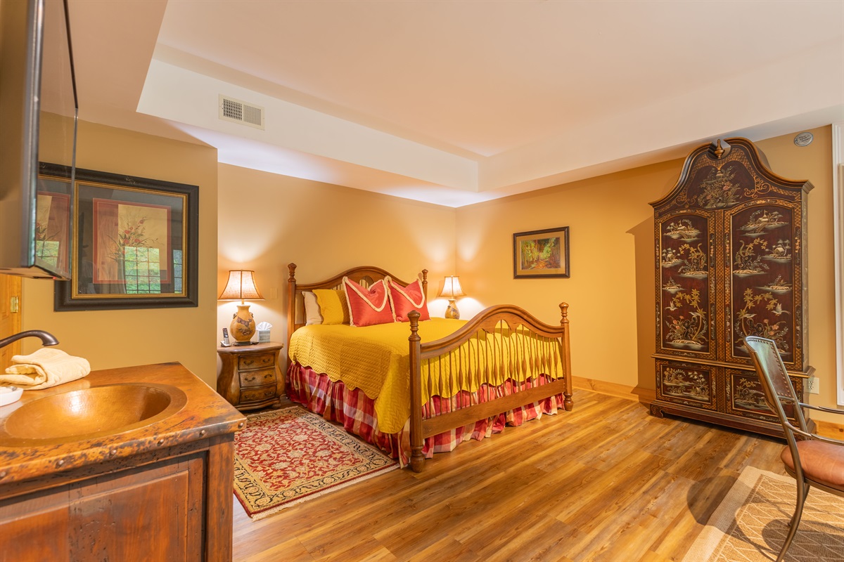 Warm wood tones, comfortable furnishings, and thoughtful details make the downstairs king suite feel both inviting and relaxing.