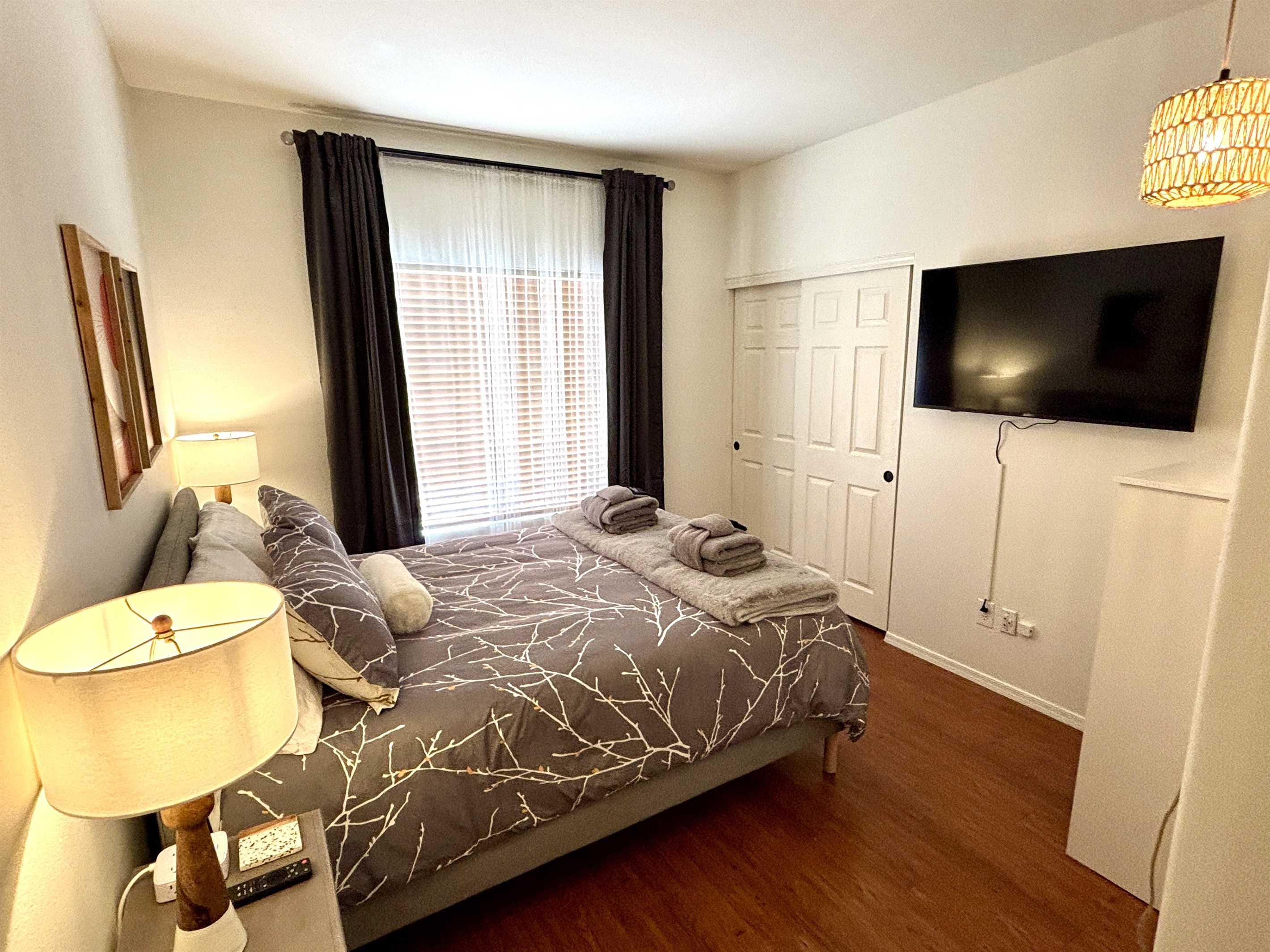 Queen bedroom downstairs with 55" smart Tv and blackout curtains