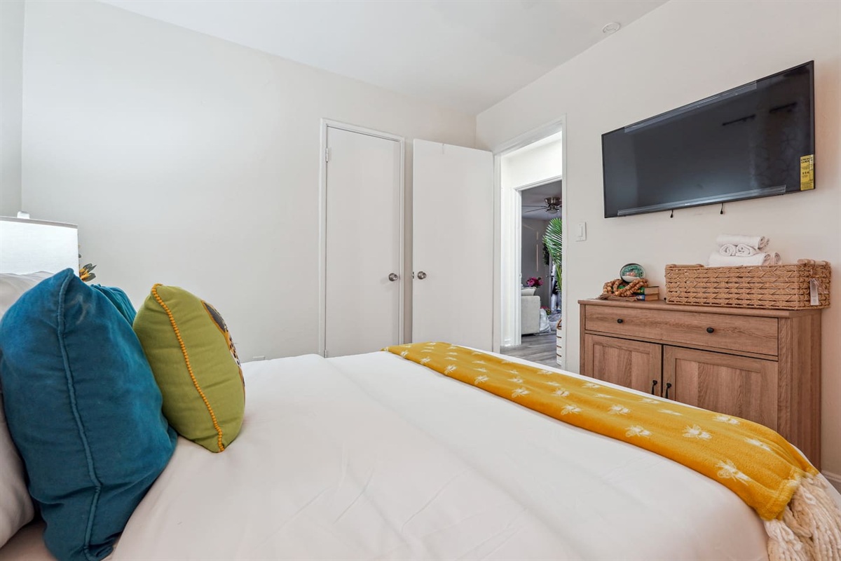 A cozy bedroom with a Queen bed, ceiling fan, TV, bedside lamp, and a spacious closet to keep your belongings organized.
