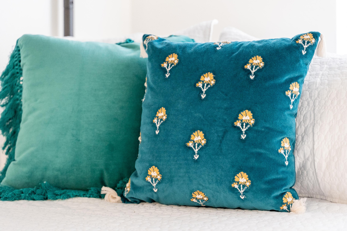Teal velvet pillows add a pop of color to this inviting bunk room.