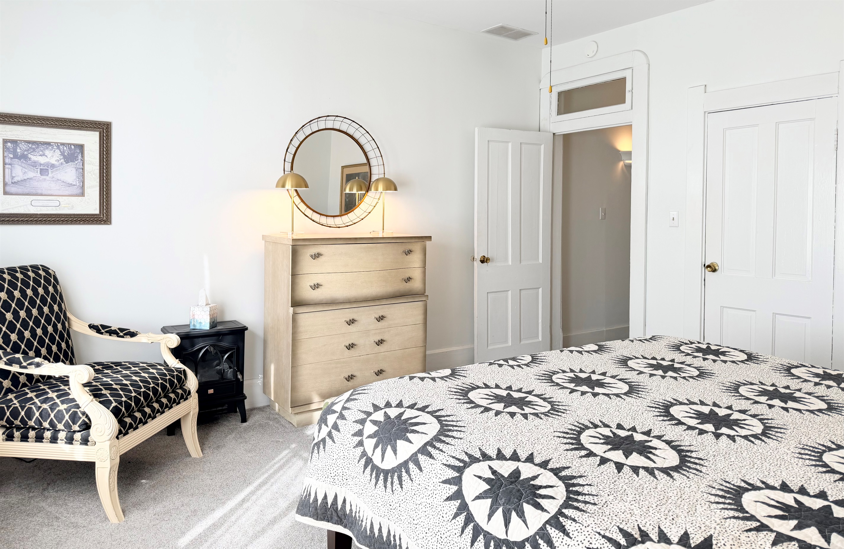 Cozy electric fireplace, vintage dresser with mirror, and a cozy sitting chair — a calm, beautifully layered corner designed for comfort and ease.