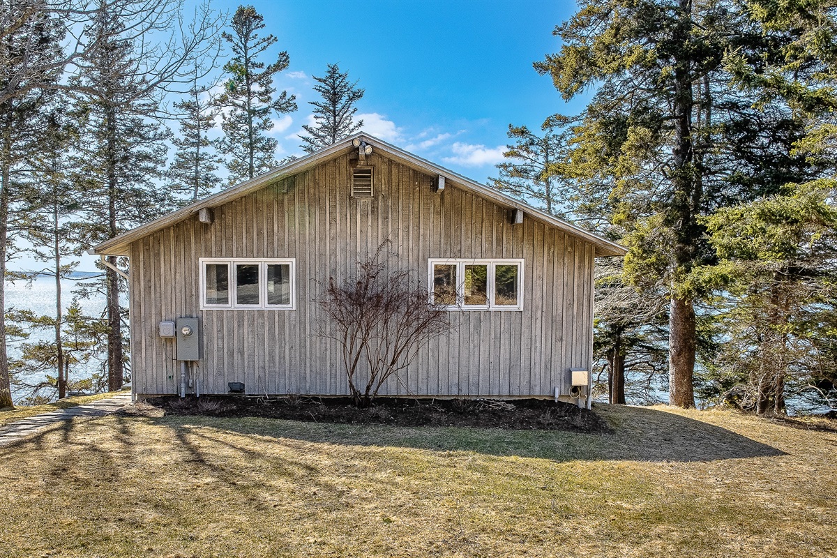 "An Architectural Sanctuary Nestled in the Pines."
Designed to disappear into the landscape, this coastal retreat hides a stunning modern interior and panoramic harbor views behind its understated cedar-toned facade.