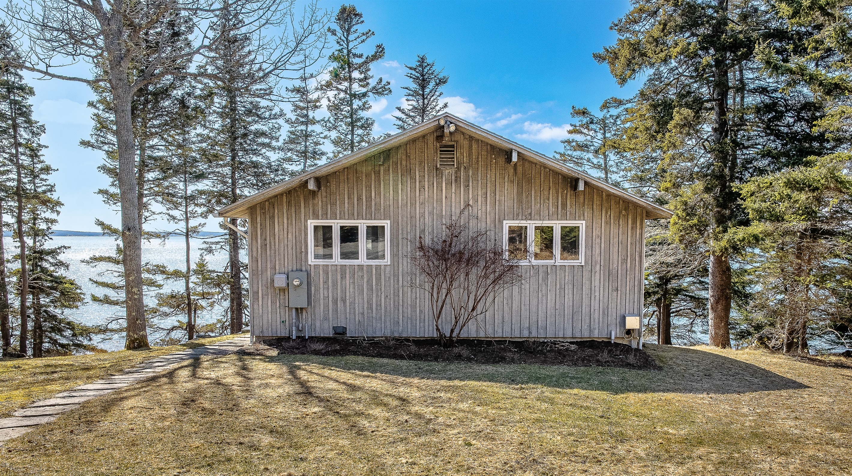 "An Architectural Sanctuary Nestled in the Pines."
Designed to disappear into the landscape, this coastal retreat hides a stunning modern interior and panoramic harbor views behind its understated cedar-toned facade.