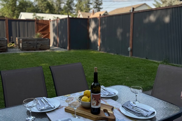 Enjoy dining outdoors on the patio in the fully fenced backyard. Then soak in the hot tub for maximum relaxation!

Guests are encouraged to create their own patio dining experience! Please note: the photographed wine is not included in your stay :) 