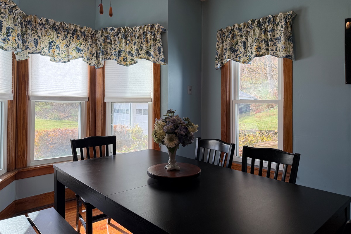 Dining room seating with beautiful bay window letting in lots of natural light.