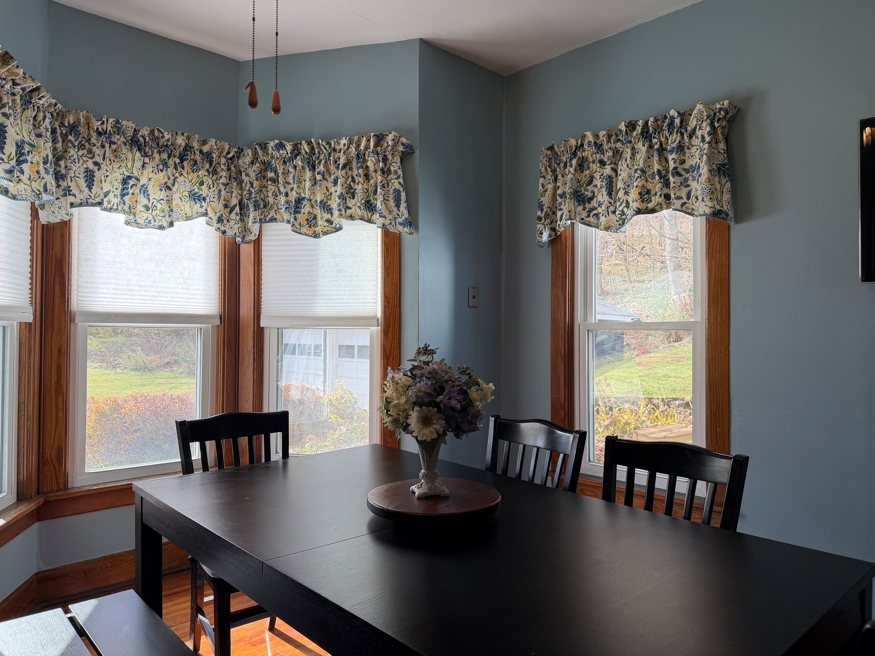 Dining room seating with beautiful bay window letting in lots of natural light.