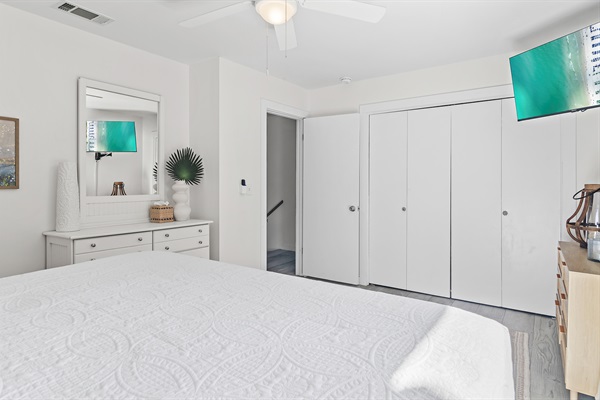 Cozy Coastal Chic Master Bedroom: Unwind in the master bedroom with a luxurious king-sized bed, private bath, and a balcony offering serene views.