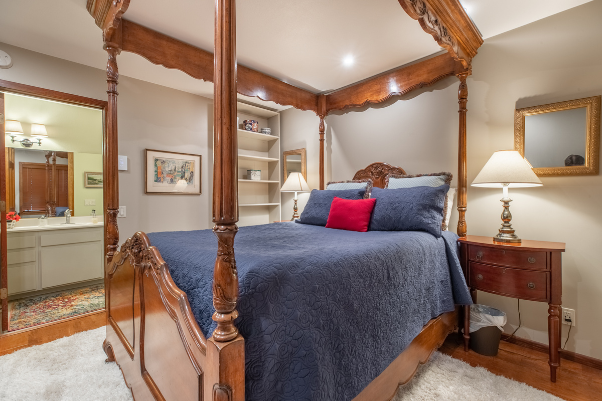 The West bedroom with Queen bed, dresser, Roku TV, bookcase, and en suite bathroom with tub.