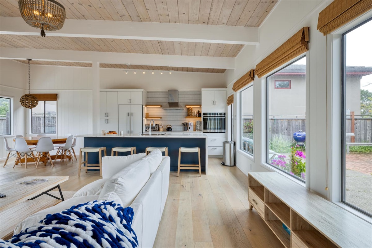 - Open living and kitchen layout with vaulted ceilings and wood flooring  
- Large windows overlook the courtyard, filling the space with sunlight  
- Kitchen island with bar seating is perfect for casual dining or drinks  
