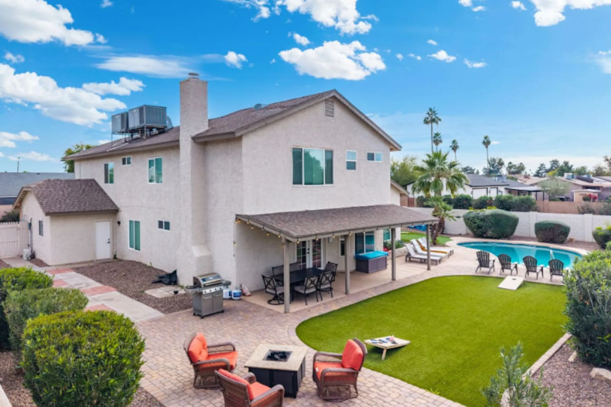 Backyard oasis with pool, covered patio, firepit, and manicured lawn—perfect for relaxation and gatherings.