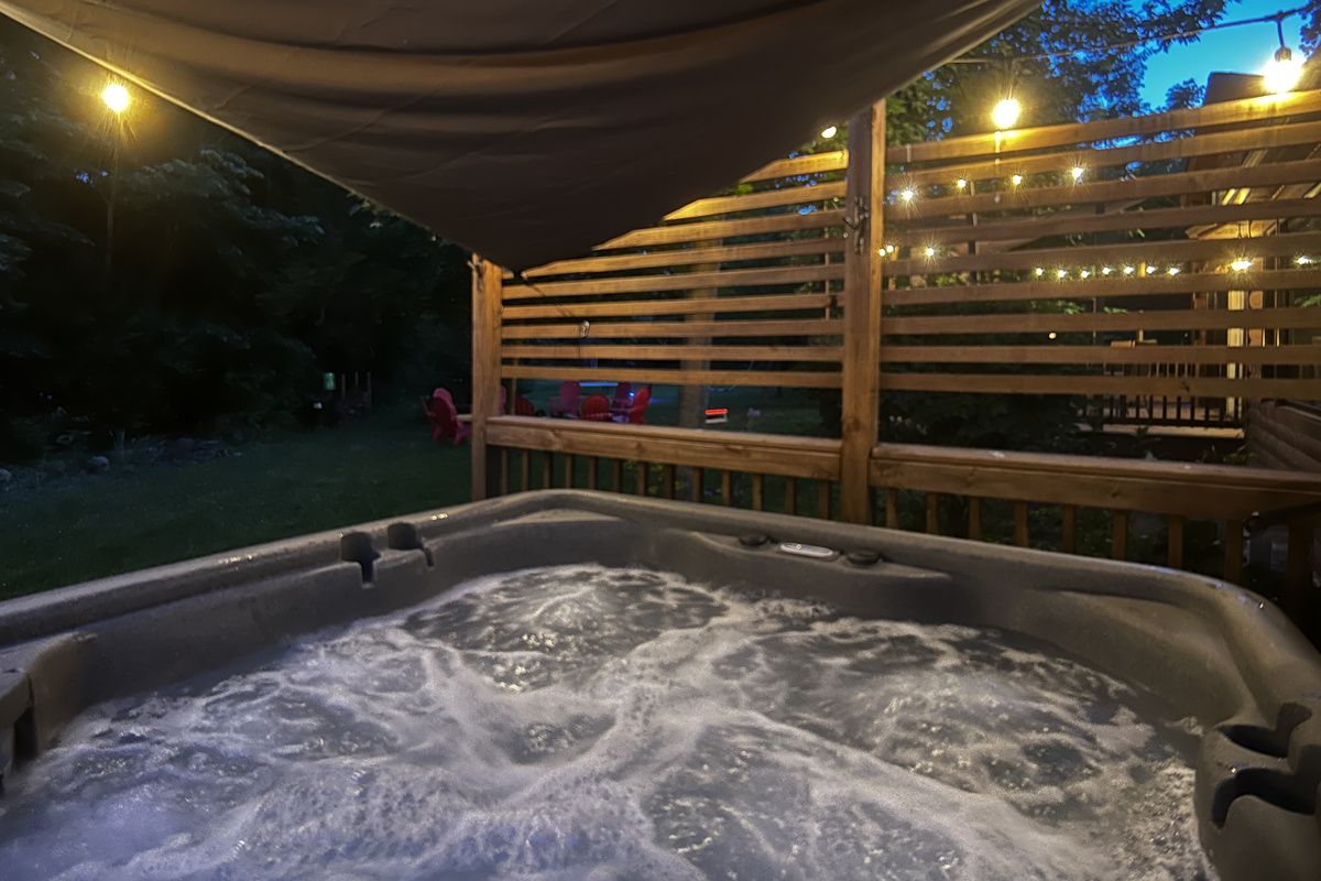 Relax in the hot tub after a fun day competing on the pickleball court. A sun sail is hung over the hot tub during warmer months.
