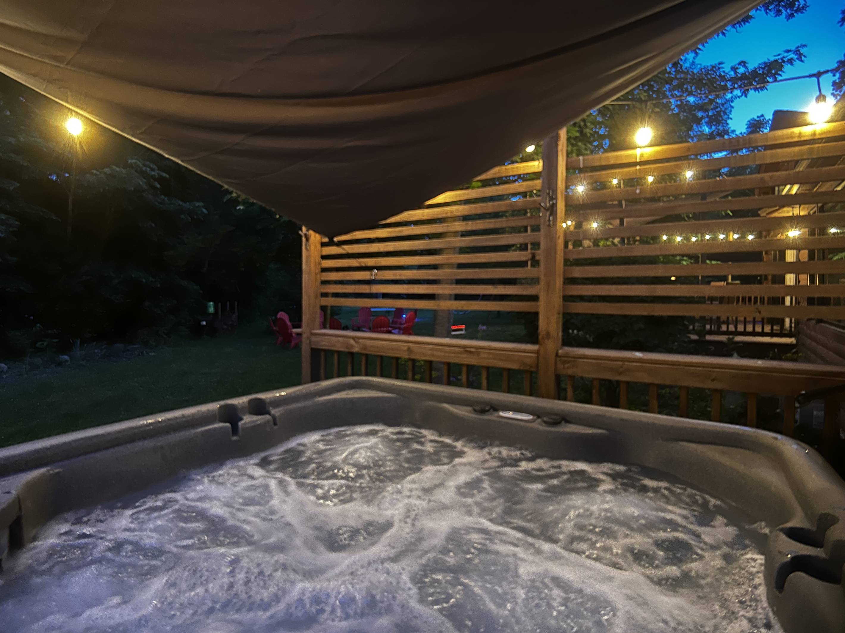 Relax in the hot tub after a fun day competing on the pickleball court. A sun sail is hung over the hot tub during warmer months.