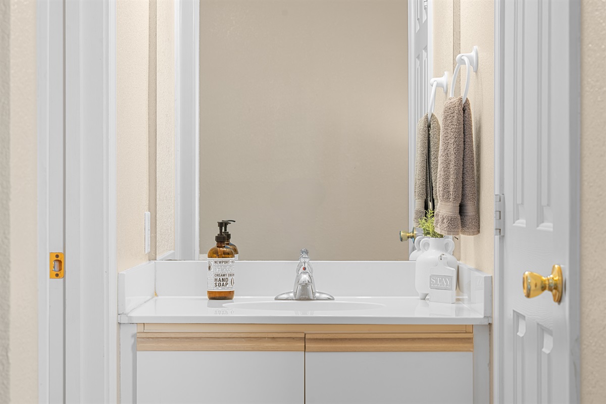 Mirror and vanity detail reinforce the bright, practical bathroom layout.