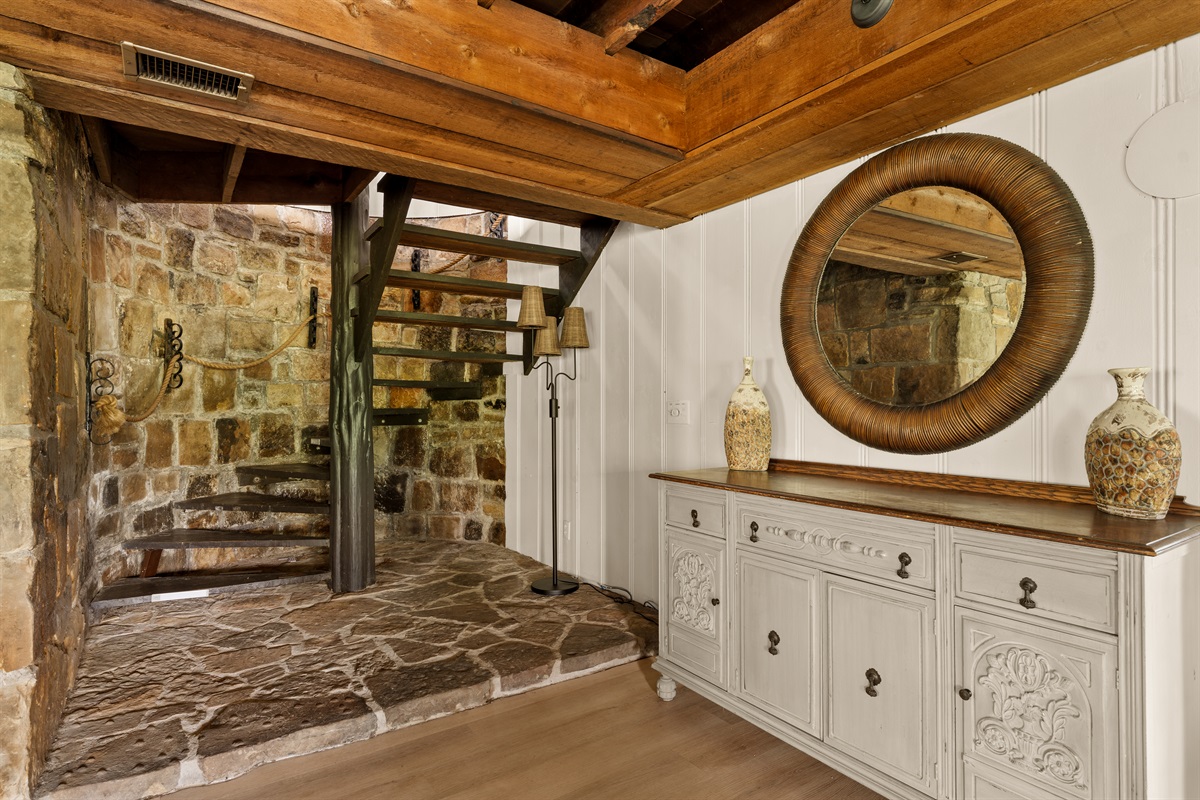 A beautifully layered space where rustic stone meets warm wood—right beneath the spiral staircase.