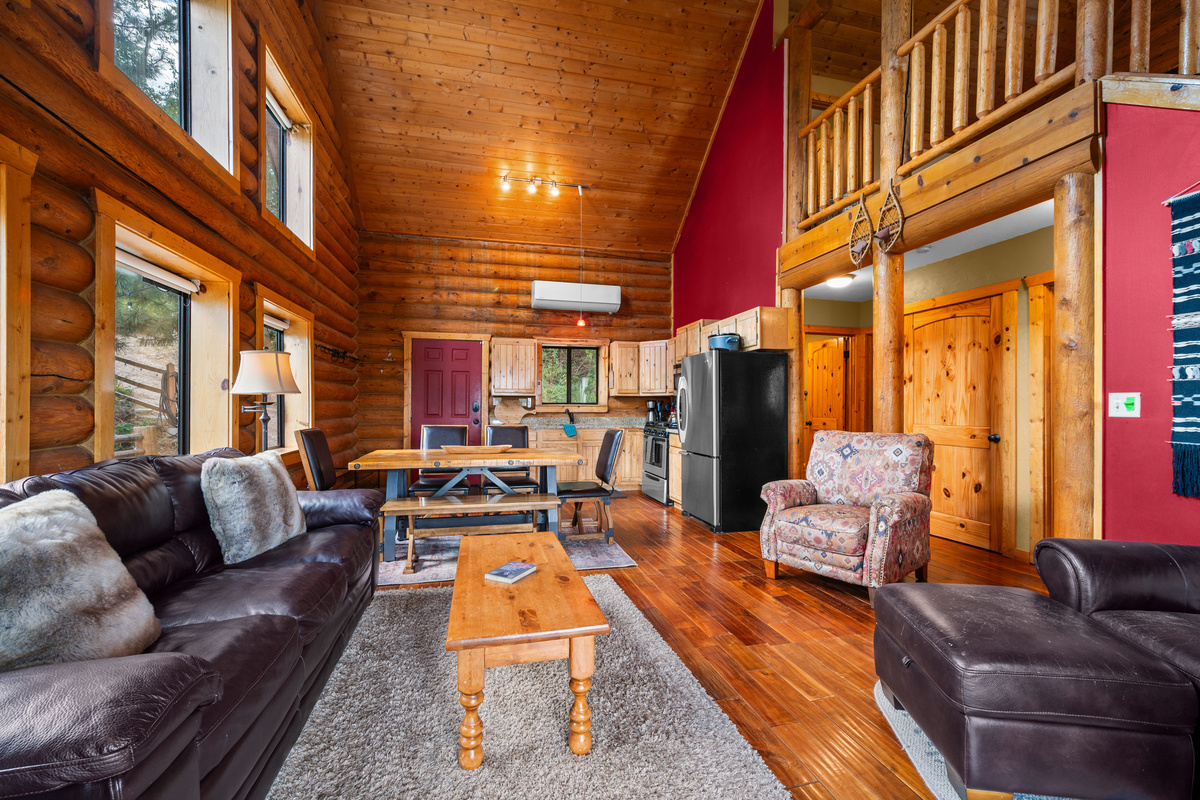 Inviting main living room with gas fireplace, vaulted wood ceilings, and mountain cabin character.